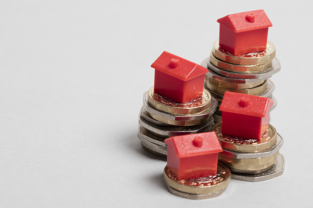 Toy houses on piles of money to signify homeowner loan