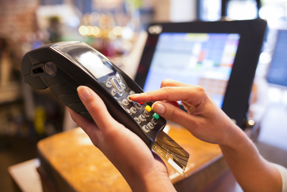 A person using a credit card to make a payment in a shop